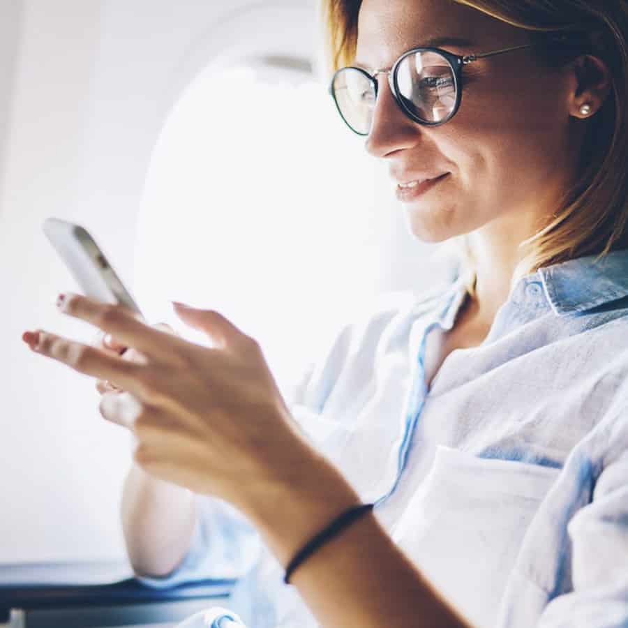 Business trip concept with a businessman touching a button on a screen with icons about travel planning, transportation, hotel, flight and passport