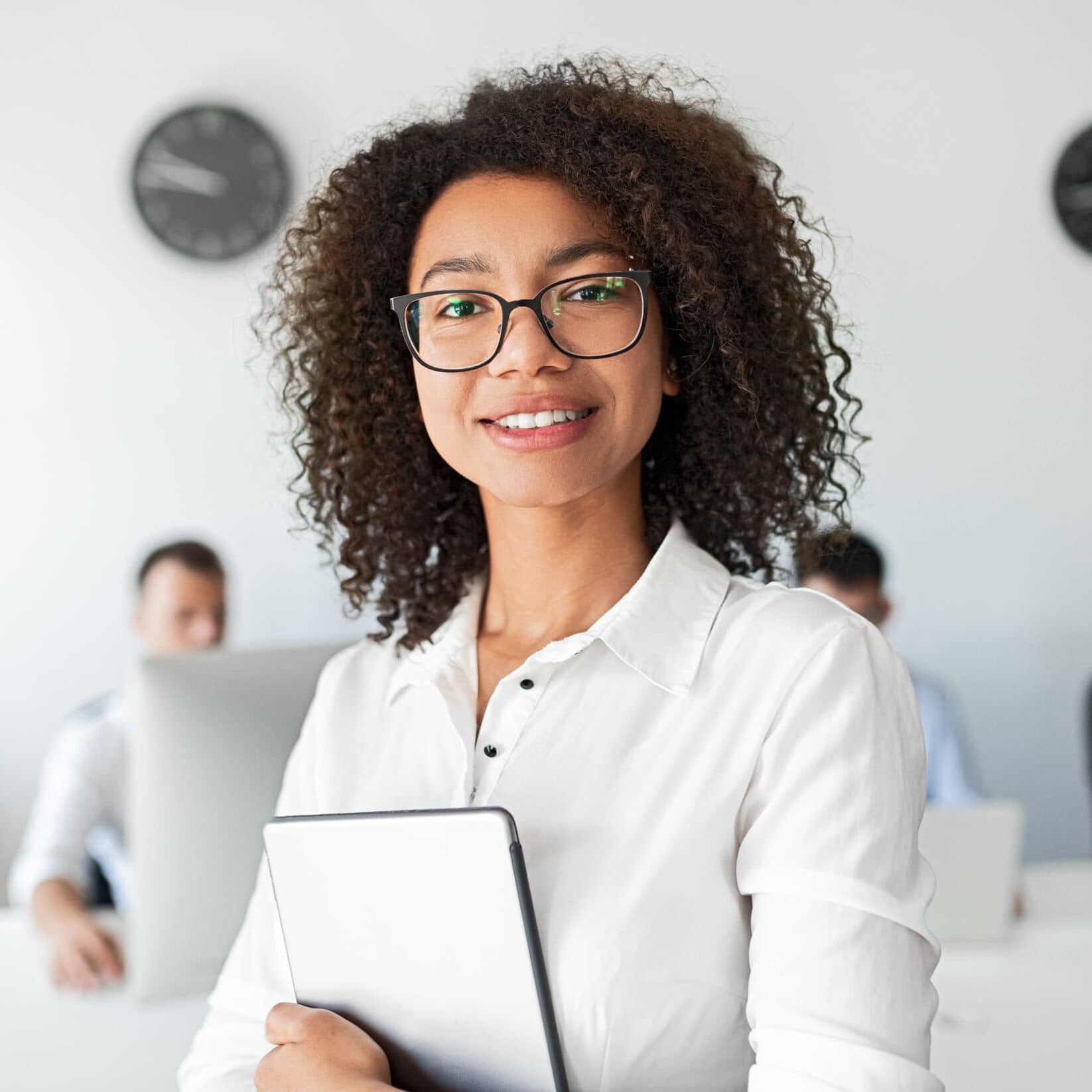 Happy African American female adviser with tablet smiling and looking at camera while working in in contemporary office