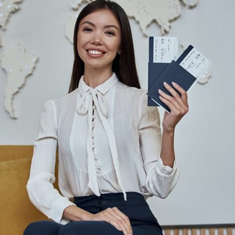 Young attractive woman travel agent with flight tickets in hands